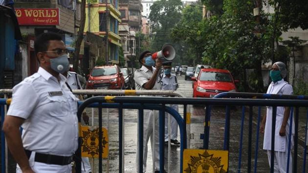 A Kolkata Police personnel uses a loudspeaker to address residents at Kankurgachi -- one of the new Covid-19 containment zones in Kolkata on Thursday,.(Samir Jana/HT PHOTO)