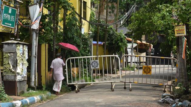 A man crosses barricades at a containment zone in Kolkata on July 8. While the country progresses with Unlock 2.0, several states have been implementing localised containment strategies in the fight against the virus. West Bengal is the latest state in this order, deciding to put its containment zones under strict surveillance for a week starting July 9. (Samir Jana / HT Photo)
