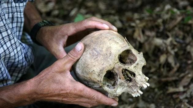 A Srebrenica genocide survivor looks at a skull that he found in the forest near Konjevic Polje, Bosnia and Herzegovina .(REUTERS)