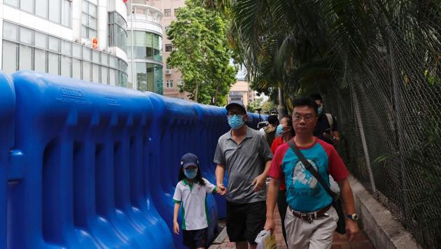 People walk past water filled barriers after the opening ceremony of temporary national security office, in Hong Kong, China July 8, 2020. (Reuters photo) People walk past water filled barriers after the opening ceremony of temporary national security office, in Hong Kong, China July 8, 2020. (Reuters photo)