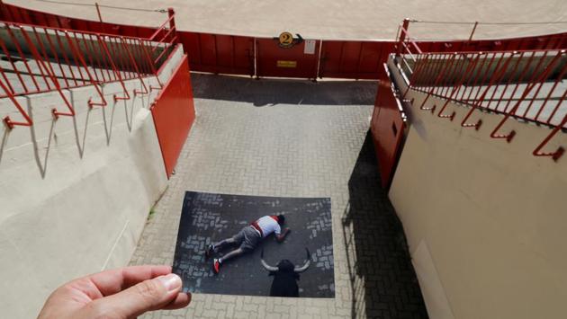 Nazca holds a picture of a reveller having fallen at the entrance of the bullring during the San Fermin festival in 2019.  (Jon Nazca / REUTERS) 