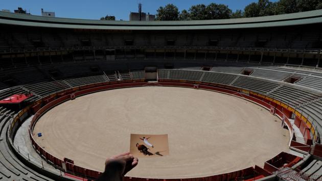 Nazca holds a picture of a recortador jumping over a bull during a contest at the San Fermin festival from July 2019. Ernest Hemingway made nine trips to the festival in his lifetime, having heard of it first from another great writer Gertrude Stein. He wrote about it in his novel, ‘The Sun Also Rises,’ in 1926. (Jon Nazca / REUTERS) 
