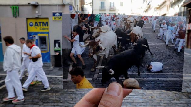 Nazca holds a picture of revelers running next to bulls at the San Fermin festival in July 2019. Tuesday, July 7 would’ve been the first day of the run-in, but the coronavirus outbreak led to the cancellation of the festival this year.  (Jon Nazca / REUTERS) 