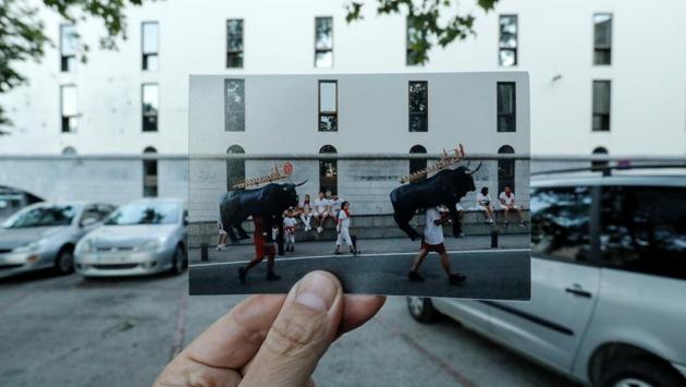Nazca holds a picture of men carrying bull figures packed with fireworks during the opening of the San Fermin festival, taken in July 2019. The bull running event is part of the larger festival, which draws thousands of visitors each year.  (Jon Nazca / REUTERS) 