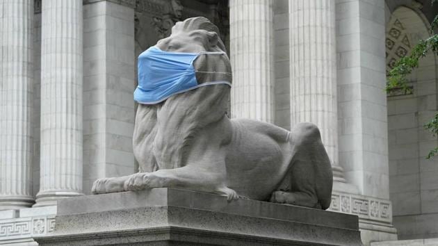 Fortitude, one of the pair of marble lions that sit in front of the New York Public Library's Fifth Avenue & 42nd Street branch is seen sporting a face mask to encourage residents to follow safety measures, on July 8. The US coronavirus outbreak crossed a grim milestone of over 3 million confirmed cases on the same day, as more states reported record numbers of new infections. (Timothy A. Clary / AFP)