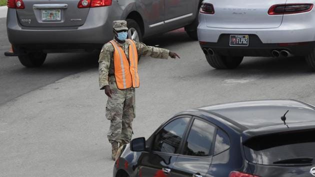 A national guardsman directs traffic at a drive-thru COVID-19 testing site outside Hard Rock Stadium in Miami Gardens, Florida on July 8. The United States is undergoing a renewed surge in cases especially in southern and westerns states, with Texas, Florida and California hit the hardest. (Wilfredo Lee / AP)