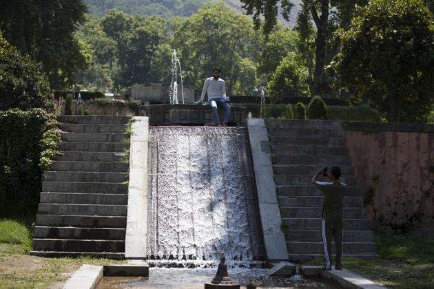 Visitors take photographs inside Mughal Garden on the outskirts of Srinagar, Kashmir, Wednesday, July 8, 2020. (AP)