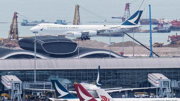 Aircraft operated by Cathay Pacific Airways Ltd. and its Cathay Dragon unit, foreground left and center, and an aircraft operated by Air China Ltd. stand on the tarmac at Hong Kong International Airport in Hong Kong, China.(Bloomberg)