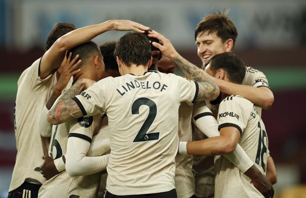 Manchester United's Paul Pogba, obscured, is congratulated by teammates after scoring his team's third goal during the English Premier League soccer match between Aston Villa and Manchester United at Villa Park in Birmingham, England, Thursday, July 9, 2020. (AP PhotoAndrew Boyers,Pool) (AP) Manchester United's Paul Pogba, obscured, is congratulated by teammates after scoring his team's third goal during the English Premier League soccer match between Aston Villa and Manchester United at Villa Park in Birmingham, England, Thursday, July 9, 2020. (AP PhotoAndrew Boyers,Pool) (AP)