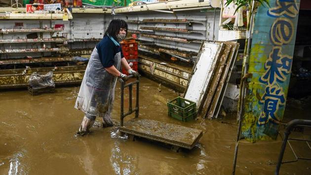A woman wades in mud water in a supermarket following heavy rains and flooding in Hitoyoshi on July 9. Floodwaters rendered useless all local produce ready to be shipped to customers. (CHARLY TRIBALLEAU / AFP)