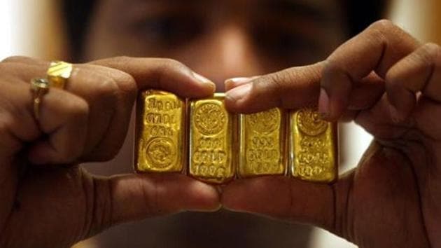 A salesman displays gold bars inside a jewellery shop in Hyderabad. (REUTERS) A salesman displays gold bars inside a jewellery shop in Hyderabad. (REUTERS)