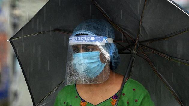 A woman wearing a face shield is seen under an umbrella amid rain in Kankurgachi, Kolkata on July 9. India’s death toll currently stands at 21,604. (Samir Jana / HT Photo) A woman wearing a face shield is seen under an umbrella amid rain in Kankurgachi, Kolkata on July 9. India’s death toll currently stands at 21,604. (Samir Jana / HT Photo)