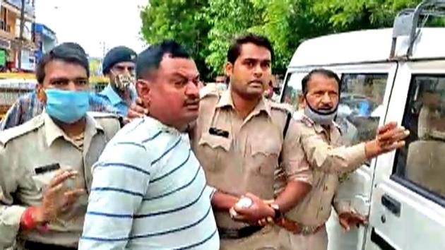 Police personnel arrest Vikas Dubey, the main accused in the Kanpur encounter Case, at the Mahakal temple, in Ujjain. (ANI Photo) (ANI) Police personnel arrest Vikas Dubey, the main accused in the Kanpur encounter Case, at the Mahakal temple, in Ujjain. (ANI Photo) (ANI)