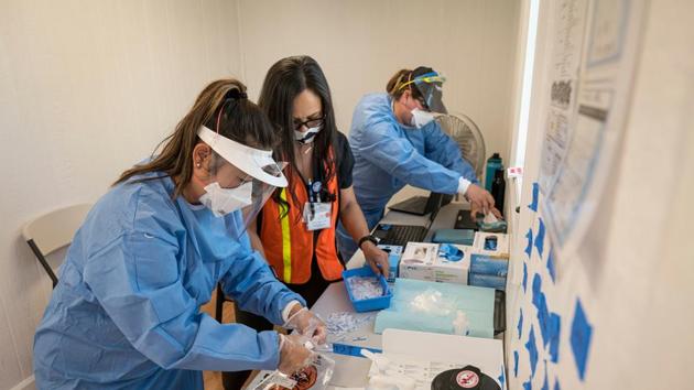 Health care workers wearing personal protective equipment work inside a trailer at a Covid-19 testing site in Concord, California, US. (Bloomberg)