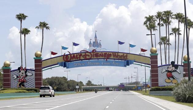 Cars drive under a sign greeting visitors near the entrance to Walt Disney World, Thursday, July 2, 2020, in Lake Buena Vista, Fla. Despite a huge surge of Floridians testing positive for the new coronavirus in recent weeks, Magic Kingdom and Animal Kingdom, two of Disney World's four parks are reopening Saturday, July 11. When they do, visitors to “The Most Magical Place on Earth” will find new rules in place. (AP) Cars drive under a sign greeting visitors near the entrance to Walt Disney World, Thursday, July 2, 2020, in Lake Buena Vista, Fla. Despite a huge surge of Floridians testing positive for the new coronavirus in recent weeks, Magic Kingdom and Animal Kingdom, two of Disney World's four parks are reopening Saturday, July 11. When they do, visitors to “The Most Magical Place on Earth” will find new rules in place. (AP)