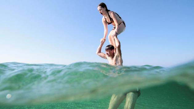 A man holds his daughter on shoulders before a jump into the waters of the Black Sea near the village of Vitino, Crimea July 4, 2020.(REUTERS) A man holds his daughter on shoulders before a jump into the waters of the Black Sea near the village of Vitino, Crimea July 4, 2020.(REUTERS)