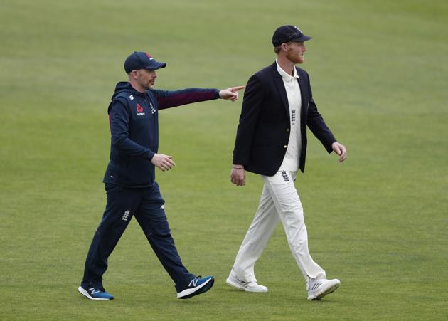 England captain Ben Stokes, right, walks back to pavilion after winning the toss as rain delayed start of the first day of the 1st cricket Test match between England and West Indies, at the Ageas Bowl in Southampton, England, Wednesday July 8, 2020. (Adrian Dennis/Pool via AP) (AP)