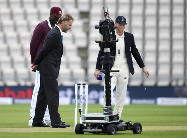 England captain Ben Stokes, right, and West Indies' captain Jason Holder, left, watch the coin before Stoke won the toss on the first day of the 1st cricket Test match between England and West Indies, at the Ageas Bowl in Southampton, England, Wednesday July 8, 2020. (Mike Hewitt/Pool via AP) (AP)