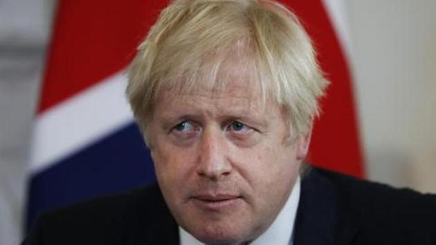 British Prime Minister Boris Johnson takes his seat as he waits for a photo inside Downing Street in London.(AP file photo)
