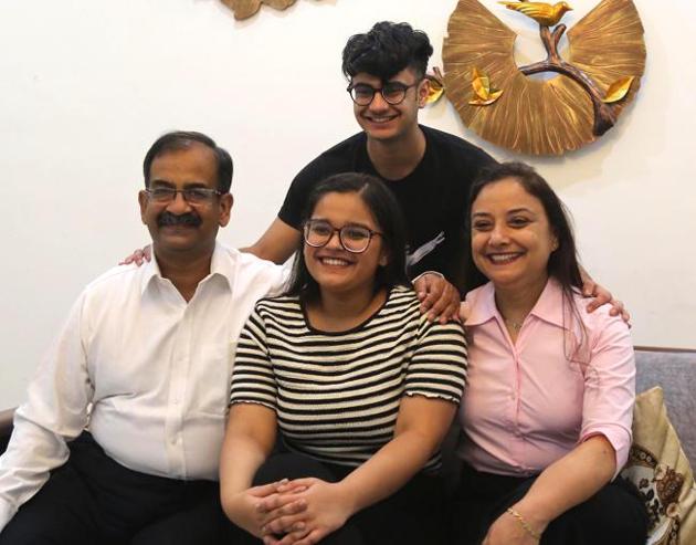 Muskan Saxena, who topped among Chandigarh, Mohali and Panchkula, with 99.25% marks, with her family at PGIMER, Chandigarh, on Friday.(Keshav Singh/HT)