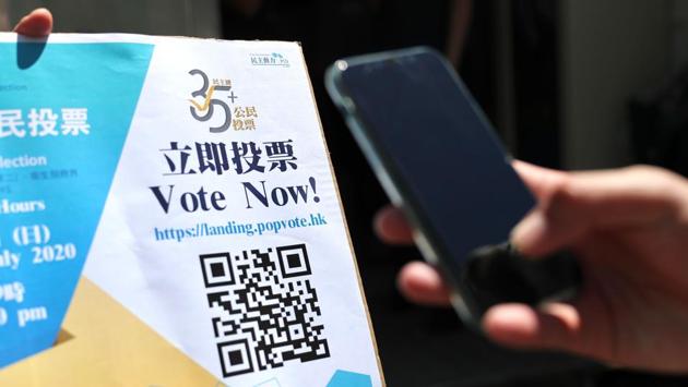 A voter scans a QR code at a polling station for New Territory East candidates during the primary polls in Hong Kong on July 11. The police raid raised concerns over the primary but PORI president Robert Chung said the voting system was safe and its operation was legal and transparent, reported AFP. (May James / AFP) A voter scans a QR code at a polling station for New Territory East candidates during the primary polls in Hong Kong on July 11. The police raid raised concerns over the primary but PORI president Robert Chung said the voting system was safe and its operation was legal and transparent, reported AFP. (May James / AFP)