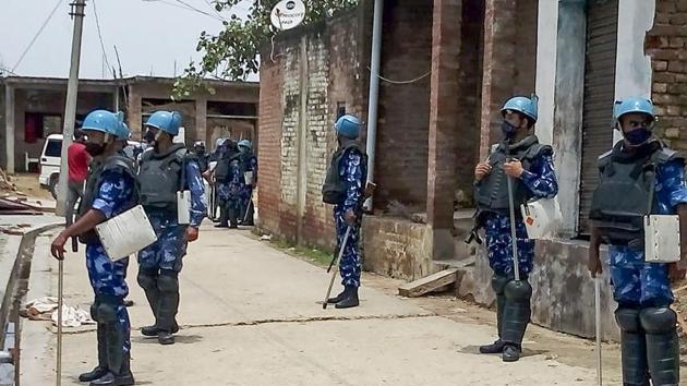 Rapid Action Force (RA)F personnel stand guard at Bikaru village near Kanpur during investigation in connection with gangster Vikas Dubey who was killed in an encounter on Friday.(PTI)