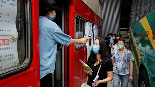A voter gets her temperature checked as she queues up to vote during the primary polls in Hong Kong on July 11. China imposed the new security law on Hong Kong last week targeting acts of subversion, secession, terrorism and foreign collusion with a maximum penalty of life imprisonment, in response to huge and often violent democracy protests that erupted last year. (Tyrone Siu / REUTERS) A voter gets her temperature checked as she queues up to vote during the primary polls in Hong Kong on July 11. China imposed the new security law on Hong Kong last week targeting acts of subversion, secession, terrorism and foreign collusion with a maximum penalty of life imprisonment, in response to huge and often violent democracy protests that erupted last year. (Tyrone Siu / REUTERS)