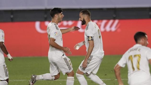 Real Madrid's Karim Benzema, right, celebrates after scoring a penalty against Deportivo Alaves with his teammate Marco Asensio during the Spanish La Liga soccer match between Real Madrid and Deportivo Alaves at the Alfredo di Stefano stadium in Madrid, Spain, Friday, July 10, 2020. (AP Photo/Bernat Armangue)(AP)
