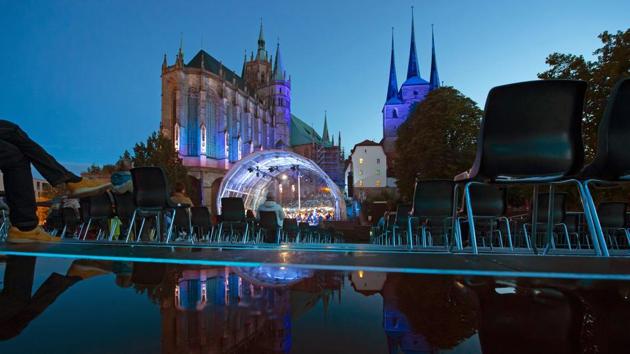 Singers and orchestra musicians perform and are reflected by a puddle at the public gallery during the rehearsal of the Cathedral Steps open air festival (Domstufen-Festspiele) in front of Mariendom (Cathedral of Mary) and St. Severi's Church in Erfurt, Germany, Wednesday, July 8, 2020. (AP) Singers and orchestra musicians perform and are reflected by a puddle at the public gallery during the rehearsal of the Cathedral Steps open air festival (Domstufen-Festspiele) in front of Mariendom (Cathedral of Mary) and St. Severi's Church in Erfurt, Germany, Wednesday, July 8, 2020. (AP)