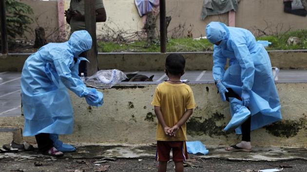 Health workers remove their protective gear after screening residents for COVID-19 symptoms at Devnar slum in Mumbai, India, Saturday, July 11, 2020.(AP)