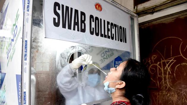 A healthcare worker collects swab sample from a woman for COVID-19 testing in Guwahati on Sunday. (ANI Photo)(ANI/For representation)