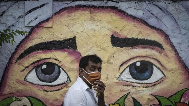 A man wearing a protective face mask walks past a wall graffiti in Pune on June 11. 28,637 new cases of the coronavirus disease (Covid-19) fuelled another record jump that pushed India’s case tally past 8.49 lakh as of the morning of July 12, according to Union Health Ministry data. (Pratham Gokhale / HT Photo) A man wearing a protective face mask walks past a wall graffiti in Pune on June 11. 28,637 new cases of the coronavirus disease (Covid-19) fuelled another record jump that pushed India’s case tally past 8.49 lakh as of the morning of July 12, according to Union Health Ministry data. (Pratham Gokhale / HT Photo)
