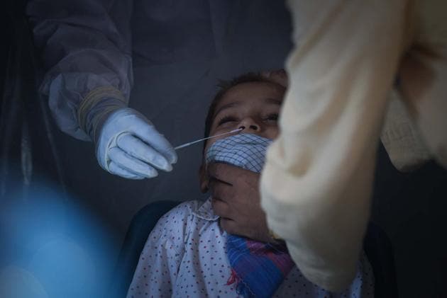 A health worker collects a swab sample from a child to test for coronavirus infection at Khajuri Khas in New Delhi.(Sanchit Khanna/HT PHOTO) A health worker collects a swab sample from a child to test for coronavirus infection at Khajuri Khas in New Delhi.(Sanchit Khanna/HT PHOTO)