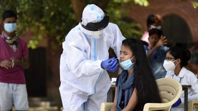 A health worker collects a swab sample from a girl for rapid antigen-testing of coronavirus, at Government Senior Secondary School, in Dundahera village near Sector-21, Gurugram, India.(HT photo) A health worker collects a swab sample from a girl for rapid antigen-testing of coronavirus, at Government Senior Secondary School, in Dundahera village near Sector-21, Gurugram, India.(HT photo)