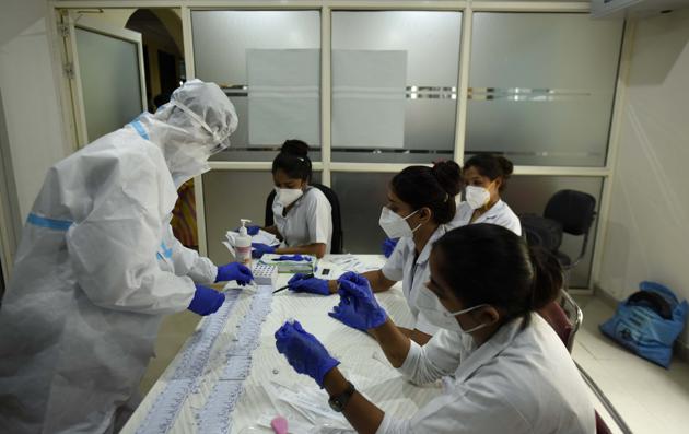 A health worker tests a sample using rapid antigen method in Gurugram on Sunday. (HT Photo) A health worker tests a sample using rapid antigen method in Gurugram on Sunday. (HT Photo)