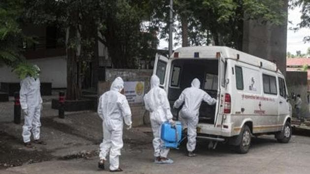 File photo: Contract workers in PPE equipment seen sanitizing the ambulance after transporting the body of a coronavirus victim at a crematorium in Pune, Maharashtra. (Pratham Gokhale/HT Photo) File photo: Contract workers in PPE equipment seen sanitizing the ambulance after transporting the body of a coronavirus victim at a crematorium in Pune, Maharashtra. (Pratham Gokhale/HT Photo)
