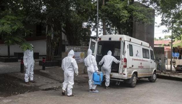 Contract workers in PPE equipment seen sanitizing the ambulance after transporting the body of a coronavirus victim, at Yerwada crematorium, in Pune. (Pratham Gokhale/HT Photo) Contract workers in PPE equipment seen sanitizing the ambulance after transporting the body of a coronavirus victim, at Yerwada crematorium, in Pune. (Pratham Gokhale/HT Photo)