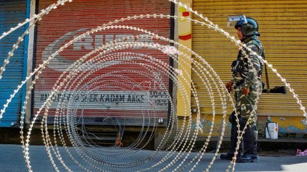 Srinagar: A security person stands guard at a blocked road in Srinagar.(PTI)