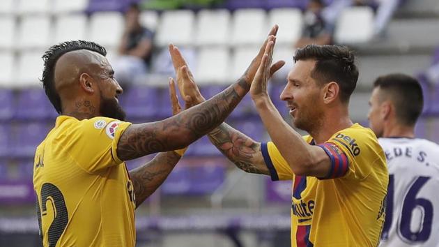 Barcelona's Arturo Vidal, left, celebrates with his teammate Lionel Messi after scoring his side's first goal during the Spanish La Liga soccer match between Valladolid and FC Barcelona at the Jose Zorrilla stadium in Valladolid, Spain, Saturday, July 11, 2020. (AP Photo/Manu Fernandez)(AP)