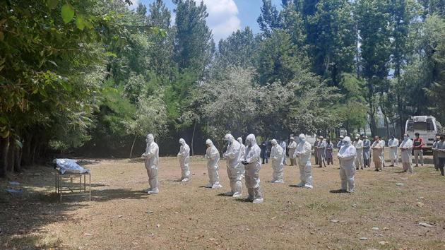 Medical workers and relatives wearing PPE coveralls seen during the funeral of a COVID-19 victim in Srinagar on July 12. India’s Covid-19 death toll has now climbed to 23,174 after the addition of 500 deaths between July 12 and July 13 morning. (Waseem Andrabi/ HT Photo) Medical workers and relatives wearing PPE coveralls seen during the funeral of a COVID-19 victim in Srinagar on July 12. India’s Covid-19 death toll has now climbed to 23,174 after the addition of 500 deaths between July 12 and July 13 morning. (Waseem Andrabi/ HT Photo)