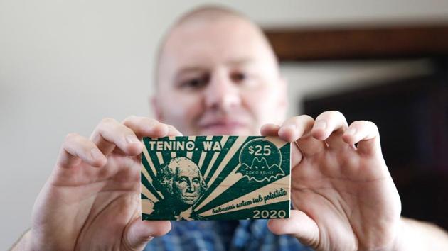 Mayor Wayne Fournier holds $25 in wooden money, in Tenino, Washington . Tenino‘s small businesses were struggling to survive due to Covid-19, so local officials revived an unconventional idea from the last century: print its own currency on planks of wood. (AFP) Mayor Wayne Fournier holds $25 in wooden money, in Tenino, Washington . Tenino‘s small businesses were struggling to survive due to Covid-19, so local officials revived an unconventional idea from the last century: print its own currency on planks of wood. (AFP)