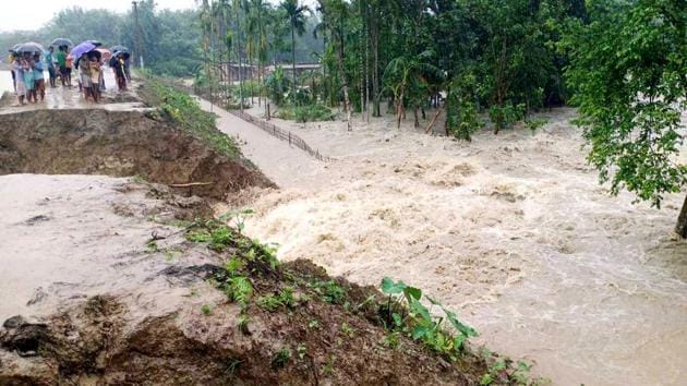 Villagers watch a washed away road due to flooding following the incessant rainfall for the past two days, at Bojali in Assam’s Barpeta on Saturday. (ANI Photo) Villagers watch a washed away road due to flooding following the incessant rainfall for the past two days, at Bojali in Assam’s Barpeta on Saturday. (ANI Photo)