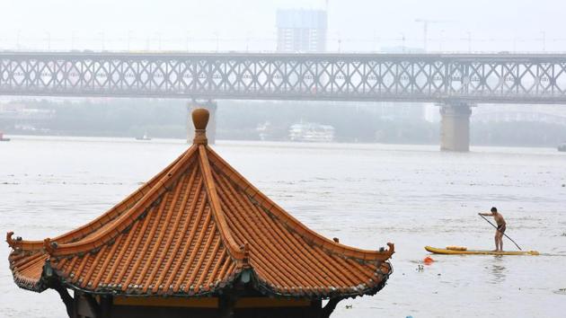 Residents swim past a riverside pavilion submerged by the flooded Yangtze River in Wuhan in central China's Hubei province Wednesday, July 8, 2020.(AP)