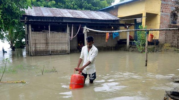 A man carries a LPG cylinder to a safer place in Morigaon on July 12. Chief minister of Assam Sarbananda Sonowal reviewed the flood situation in the state and directed the deputy commissioners to take the help of National Disaster Response Force (NDRF) and State Disaster Response Fund (SDRF) personnel for reaching out to affected people, reported PTI. (ANI)