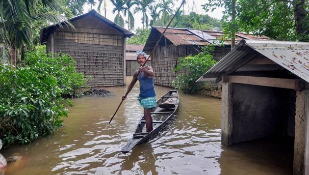 A man uses a country boat to move across a flooded locality in Assam’s Kamrup district on July 13. Incessant rainfall over the week in Assam has led rivers to overflow and caused unexpected flood occurrence in districts like Bongaigaon, Baksa, Kamurp Rural Rangia and Barpeta. (PTI)