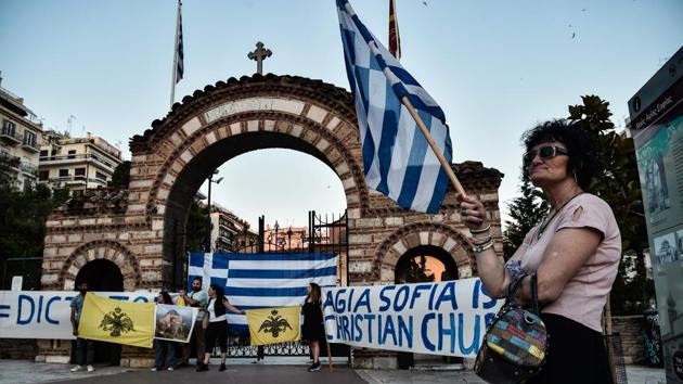 People demonstrate with banners and Greek national flags against the conversion outside the Agia Sofia church of Thessaloniki on July 10. The move by Turkey threatens to deepen tensions with neighbouring Greece, whose Prime Minister, Kyriakos Mitsotakis has condemned the decision as an affront to Hagia Sophia’s ecumenical character. (Sakis Mitrolidis / AFP)