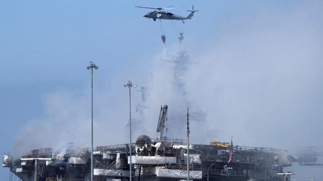 The USS Bonhomme Richard, an amphibious assault ship whose size ranks second in the US Navy fleet to that of an aircraft carrier, remained largely shrouded in thick, acrid smoke on Monday.(REUTERS)
