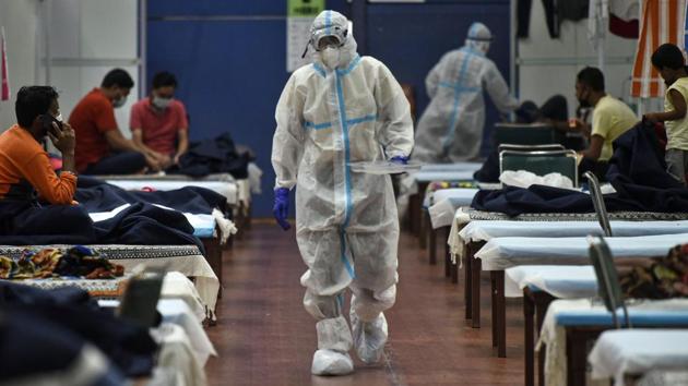 A health worker in PPE coveralls at the Commonwealth Games Village care centre in New Delhi on July 12. On July 13, 1,246 cases were reported, while 1,344 people recovered. There have been a total of 113,740 cases in Delhi, of which almost 91,312 have recovered, reported HT. (Biplov Bhuyan / HT PHOTO) 