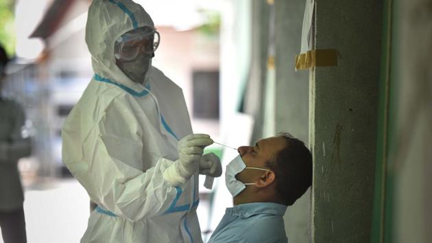 A health worker collects a swab sample from a man at a government school in Turkman Gate on July 13. Delhi has recorded 26,380 people falling ill to Covid-19 between July 1-13, while 32,984 people recovered in this period. Recoveries have outpaced fresh cases every day this month barring July 1 and July 6. (Sanchit Khanna / HT Photo)