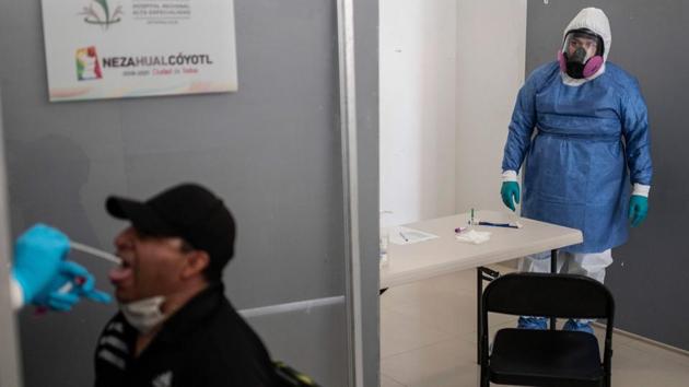A health worker collects a swab sample from a man to get him tested for COVID-19 in Nezahualcoyotl on July 13. Mexico became the fourth country with the most number of coronavirus deaths in the world after the past week saw a record daily numbers of new infections in the country. (Pedro Pardo / AFP) A health worker collects a swab sample from a man to get him tested for COVID-19 in Nezahualcoyotl on July 13. Mexico became the fourth country with the most number of coronavirus deaths in the world after the past week saw a record daily numbers of new infections in the country. (Pedro Pardo / AFP)